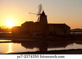 Saltworks and the picturesque windmill at the Stagnone lagoon, Marsala, Sicily, Italy, Europe.
