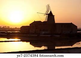 Saltworks and the picturesque windmills at the Stagnone lagoon, Marsala, Sicily, Italy, Europe.