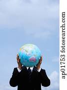 Businessman holding globe in front of his face