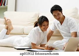 Couple at home looking at laptop Couple at home looking at laptop