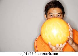 hombre, tenencia, bola de bowling, delante de, cara