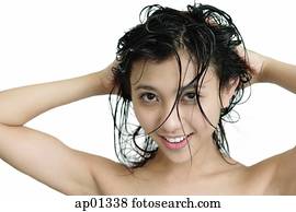 Woman washing her hair, looking at camera Woman washing her hair, looking at camera