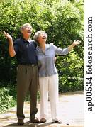 Senior couple looking up, hands outstretched Senior couple looking up, hands outstretched