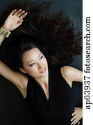 Eine Frau, die auf dem Boden liegt, lächelt und wegschaut