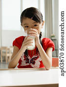 Girl sitting at table, drinking glass of milk Girl sitting at table, drinking glass of milk