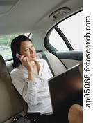 Businesswoman in car using laptop and mobile phone Businesswoman in car using laptop and mobile phone