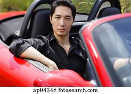 hombre que sienta, en, rojo, convertible, car,, el mirar, camera,, retrato