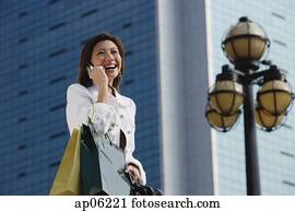 mujer, proceso de llevar, compras, bags,, utilizar, teléfono móvil