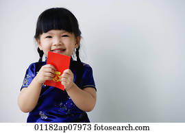 A small girl holds a red packet as she looks at the camera