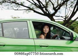 A young woman drives a green car A young woman drives a green car