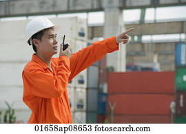 Construction worker giving directions on walkie talkie