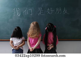 three young girls looking at Chinese characters three young girls looking at Chinese characters