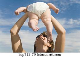 de baby van de moederholding, op, in lucht