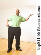 African man holding out waistband of big pants