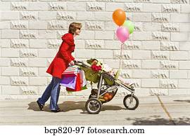 Woman pushing baby girl in stroller