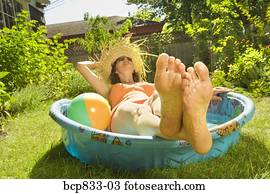 Woman lying in a wading pool