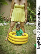 mujer, con, niño joven, juego, en, piscina