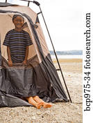 Young children playing in tent on beach