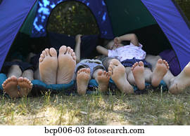 Family's feet sticking out of tent on camping trip. Family's feet sticking out of tent on camping trip.
