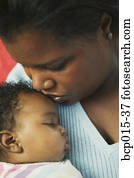 Close-up of a mother holding her baby girl close. 