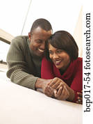 Couple holding hands on the floor.