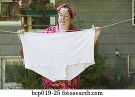Woman hanging oversized underwear on a clothesline.