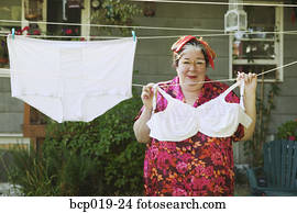 Woman hanging oversized underwear on a clothesline.