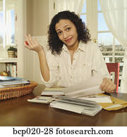 Exasperated woman working on a stack of bills.