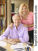 Portrait of a middleaged couple in their home office paying bills.