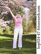 A senior woman with outstretched arms