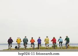 Nine people riding stationary bikes