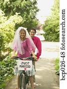 Newlyweds riding a tandem bike Newlyweds riding a tandem bike
