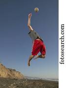 vista baixa ângulo, de, um, homem jovem, pular, ar, alcançar, um, voleibol