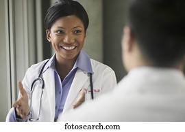 Young female doctor talking to a person smiling