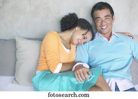 Portrait of mid adult man sitting with a young woman close to him