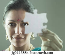 Close-up of a mid adult woman holding a jigsaw piece