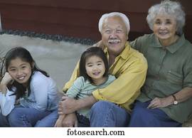 Portrait of a senior couple sitting with their granddaughters Portrait of a senior couple sitting with their granddaughters
