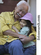 Portrait of a senior man embracing his granddaughter