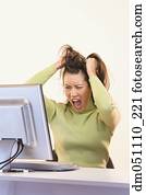 Frustrated businesswoman pulling on hair in front of computer