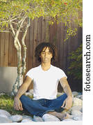 Teenage boy meditating outdoors