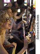 Young woman playing the slot machines in a casino
