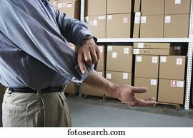 Close up of businessman rolling up his sleeve in warehouse