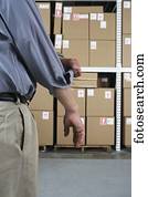 Close up of businessman rolling up his sleeve in warehouse