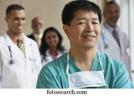 Male Asian surgeon with co-workers in the background