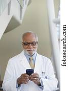 Senior male African doctor using electronic organizer