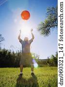 Boy throwing ball in bright sunlight