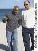 Two senior men talking on beach