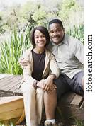 Middle-aged African couple smiling on dock