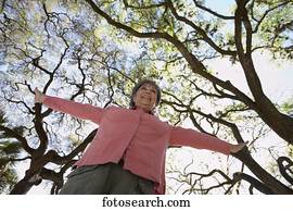 Low angle view of senior woman with arm outstretched outdoors