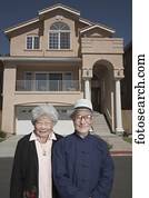 Senior Asian couple in front of house